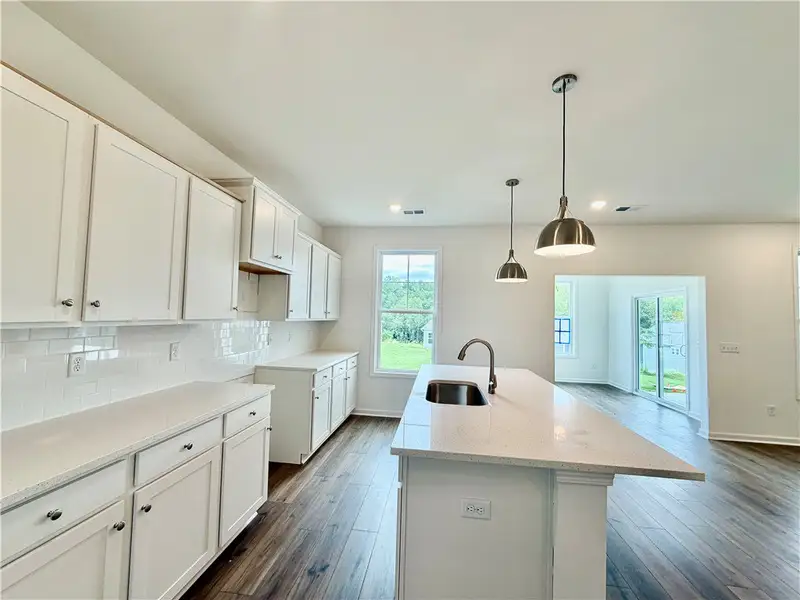 Gleaming stone countertops and wood flooring defin