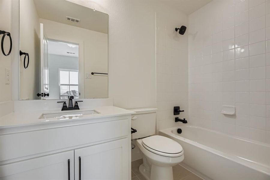 Bathroom featuring vanity, shower / bath combination, and tile patterned floors Bathroom featuring vanity, shower / bath combination, and tile patterned floors
