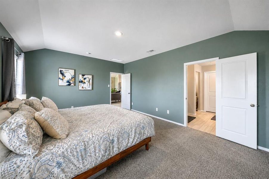 Vaulted ceiling room featuring ample natural light from a window with dark drapes, recessed lighting, and soft carpet flooring