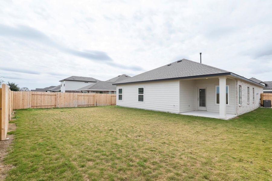 Back of house with a fenced backyard, a patio area, and a shingled roof