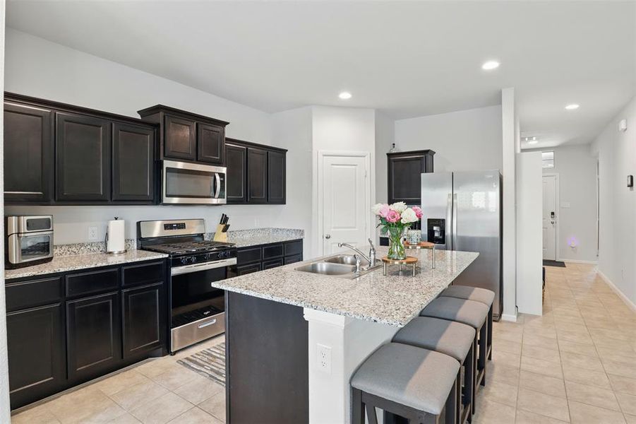 Kitchen with light tile patterned floors, recessed lighting, large island, and stainless steel appliances