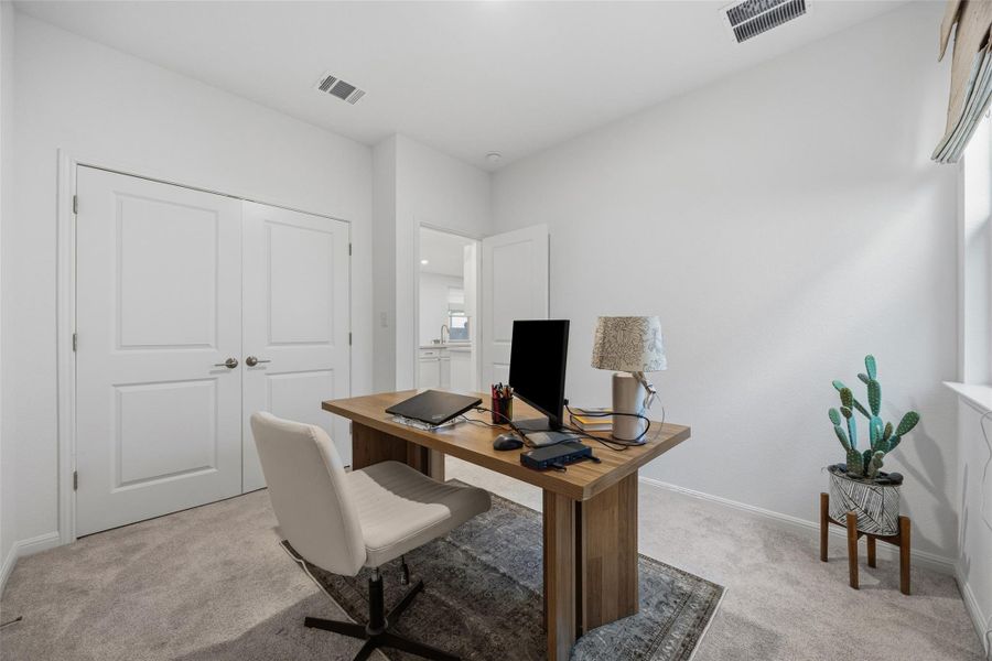 Versatile room featuring light gray carpeting, crisp white walls, white paneled double doors, and a window with natural light