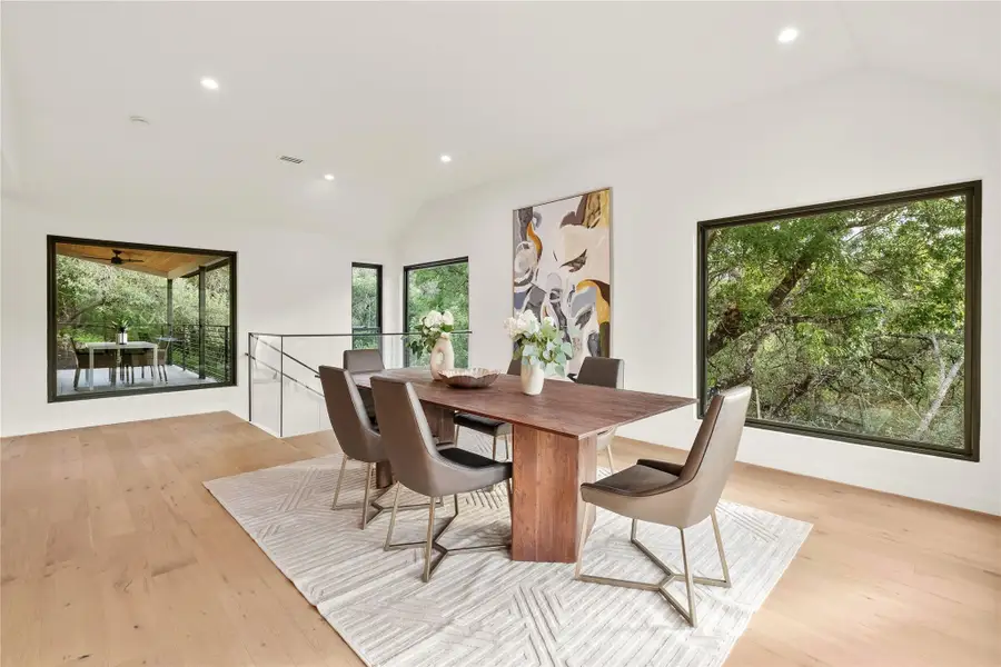 Dining space featuring lofted ceiling, healthy amount of natural light, light wood finished floors, and recessed lighting