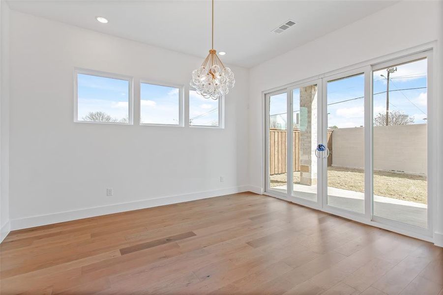 Unfurnished room with an inviting chandelier and wood-type flooring