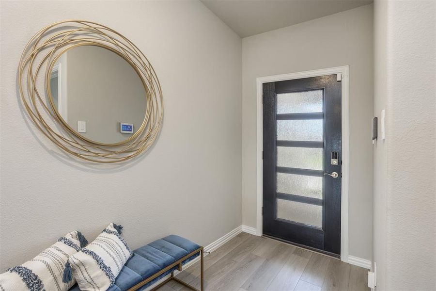 Foyer entrance featuring light wood-type flooring and baseboards Foyer entrance featuring light wood-type flooring and baseboards