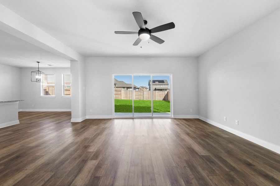 Unfurnished room with dark wood finished floors, ceiling fan, healthy amount of natural light, and a chandelier