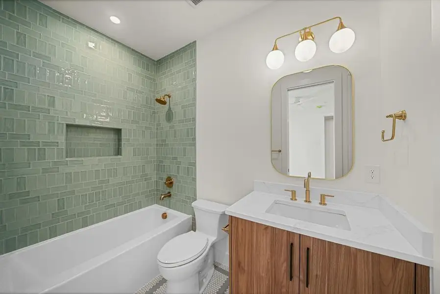 Bathroom featuring a tub/shower combination with green subway tile surround and integrated niche Bathroom featuring a tub/shower combination with green subway tile surround and integrated niche
