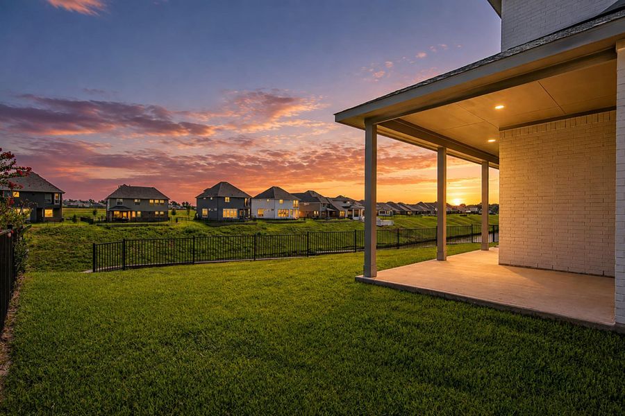 Twilight view of the covered patio and expansive fenced backyard