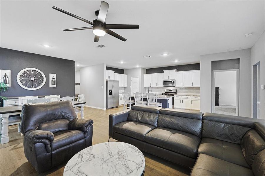 Living room featuring ceiling fan and light hardwood / wood-style flooring