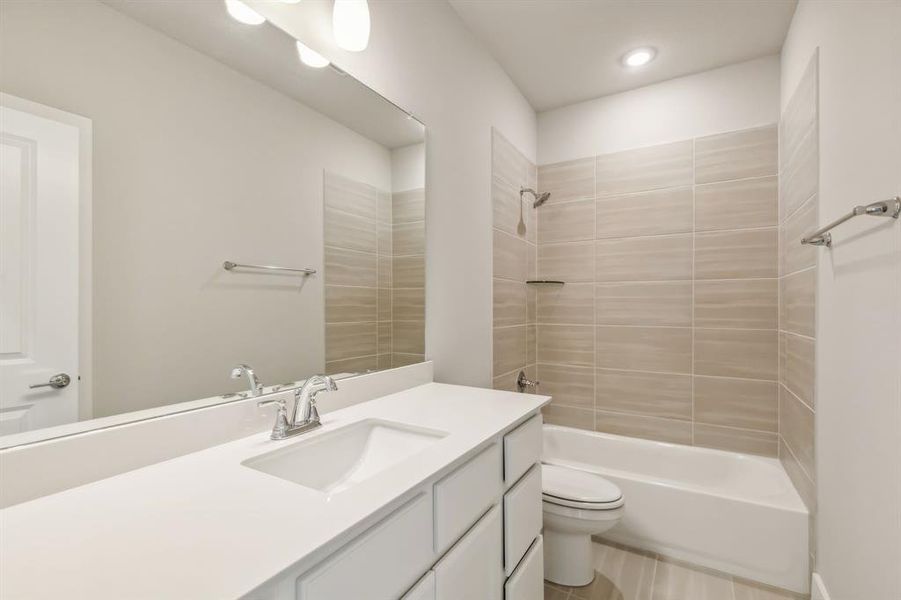 Full bathroom featuring vanity, toilet, and tiled shower / bath