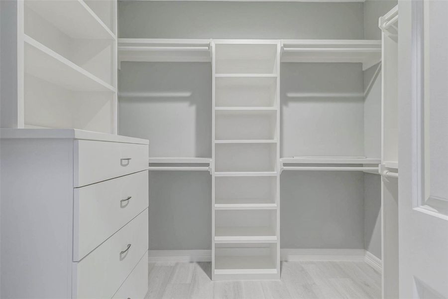 Primary closet offers built-ins and plenty of shelving.