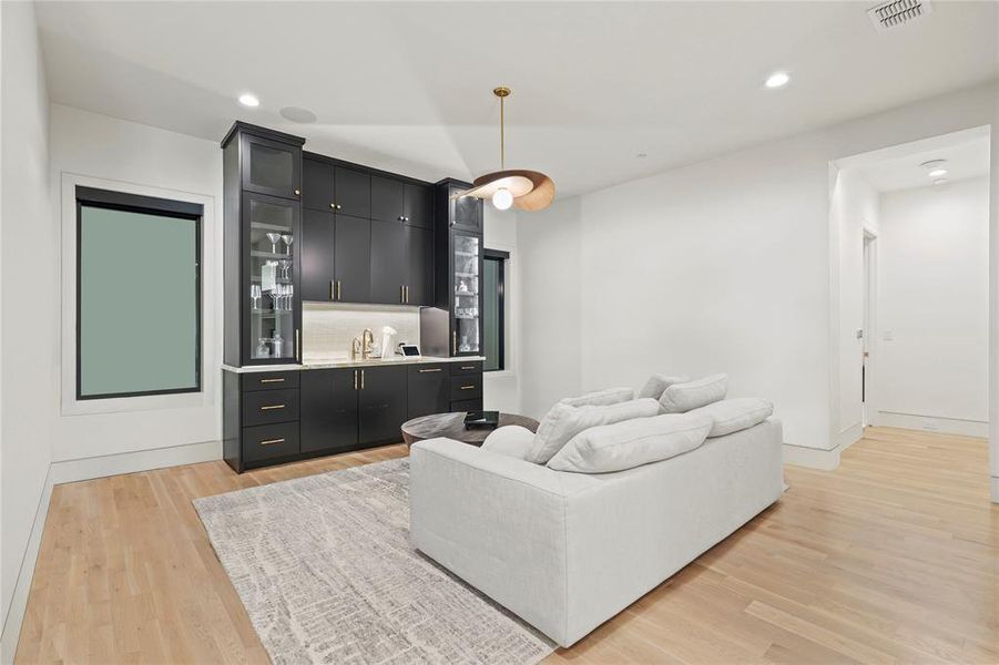 Living area featuring light wood finished floors, recessed lighting, and wet bar Living area featuring light wood finished floors, recessed lighting, and wet bar