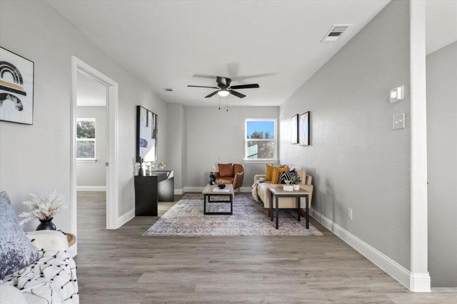 Living area featuring ceiling fan and light hardwood / wood-style flooring