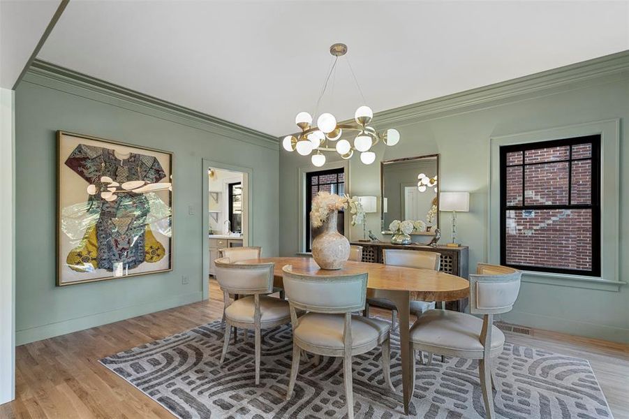 Dining room with crown molding, a notable chandelier, and hardwood / wood-style floors