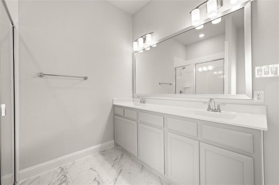 Bathroom featuring baseboards, separate shower stall, marble look tile flooring, and double vanity Bathroom featuring baseboards, separate shower stall, marble look tile flooring, and double vanity