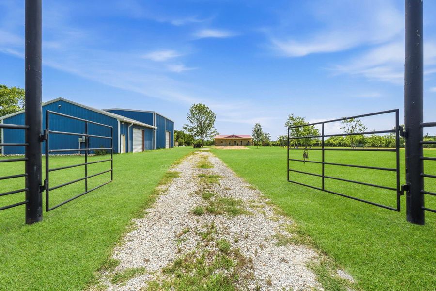 Gated entry provides added security and privacy, while the long driveway offers ample parking and a welcoming approach to both the main home and expansive shop.