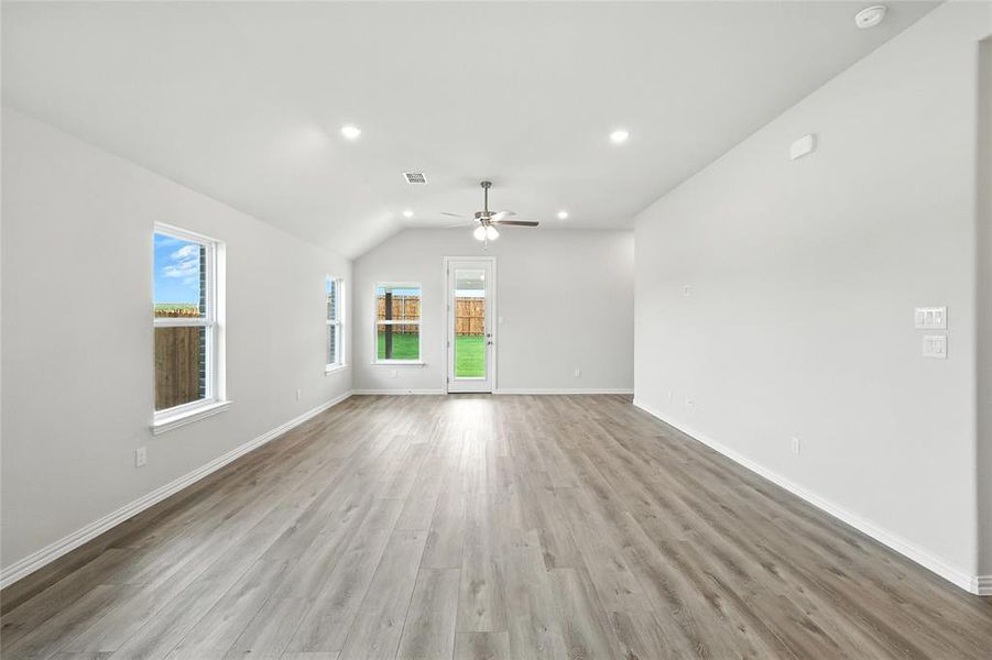 Unfurnished living room featuring ceiling fan, light wood-type flooring, vaulted ceiling, and recessed lighting