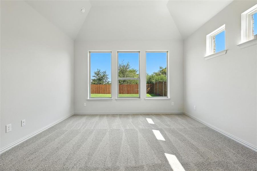 Empty room featuring light carpet and lofted ceiling Empty room featuring light carpet and lofted ceiling