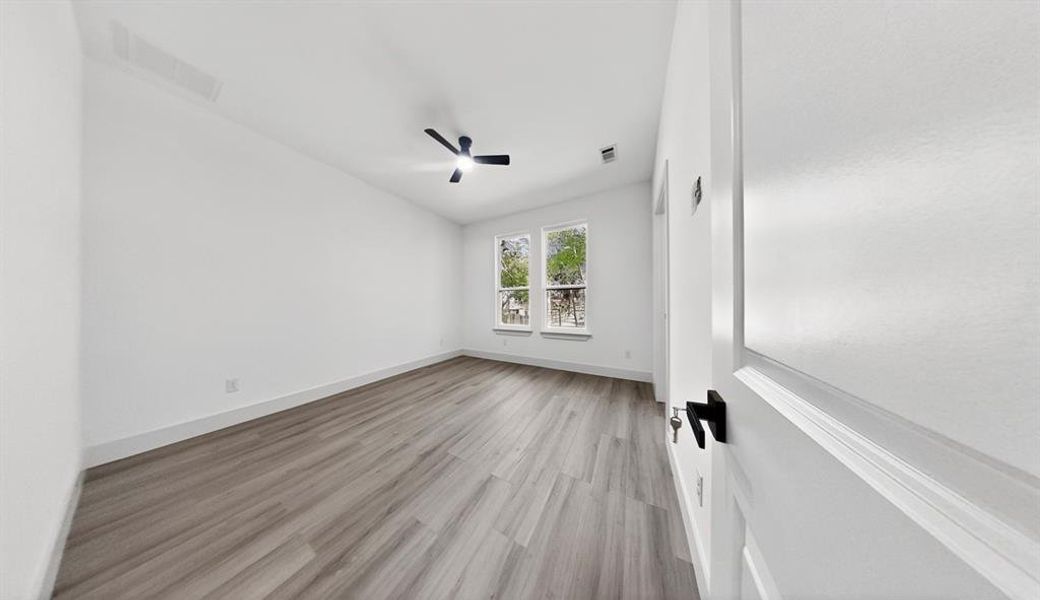 Empty room featuring light wood-style flooring and ceiling fan