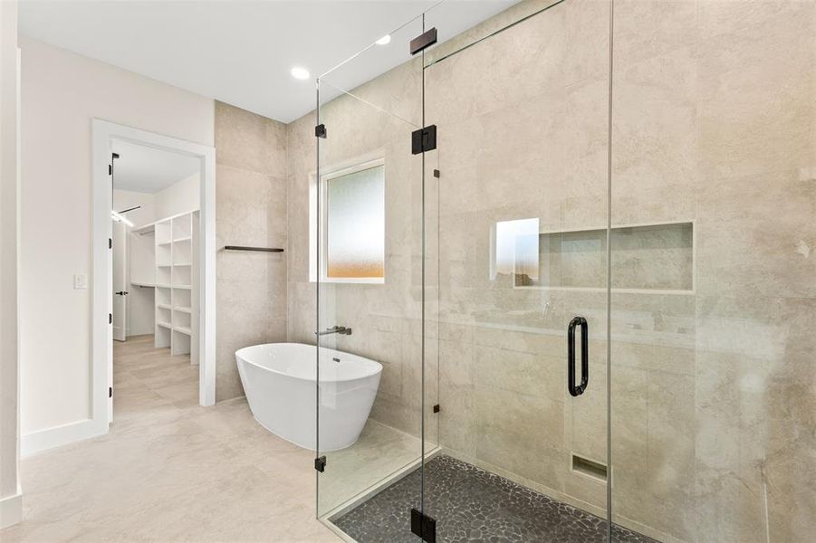 Contemporary bathroom featuring a frameless glass shower enclosure, a freestanding soaking tub, and a frosted window