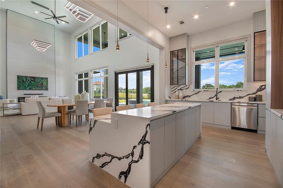 Kitchen featuring modern cabinets, light wood finished floors, open floor plan, white cabinetry, and recessed lighting
