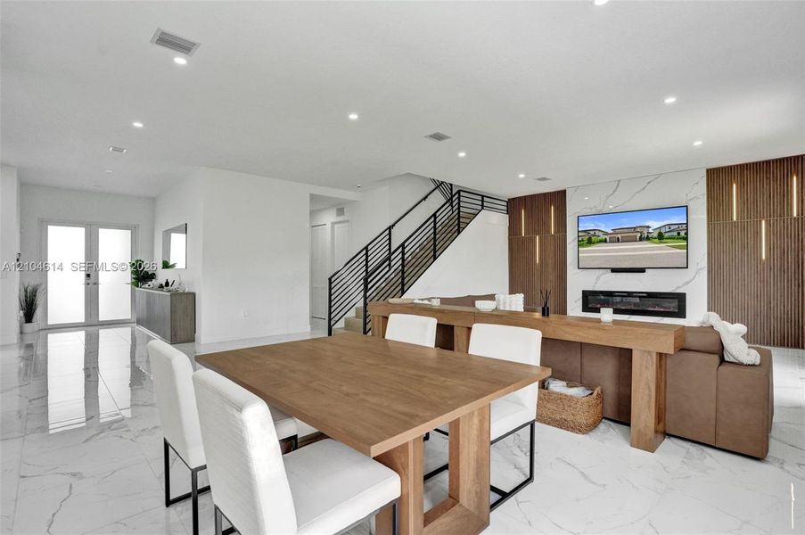 White tile flooring, recessed lighting, and a modern staircase with black railings