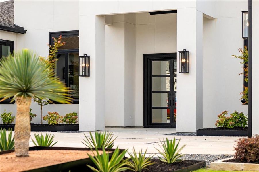View of exterior entry featuring stucco siding and french doors