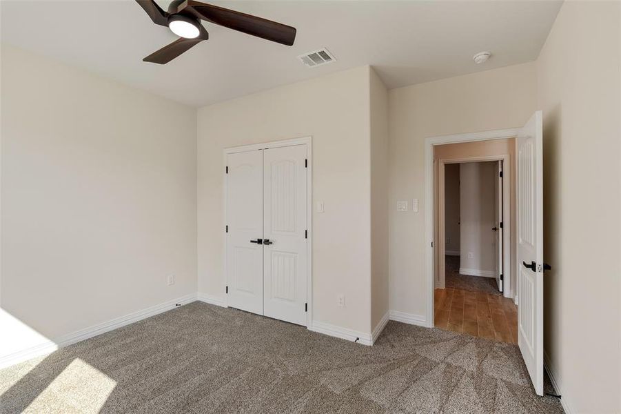 Unfurnished bedroom with a closet, ceiling fan, and light colored carpet