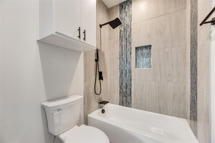 Bathroom featuring bathtub / shower combination and toilet Bathroom featuring bathtub / shower combination and toilet