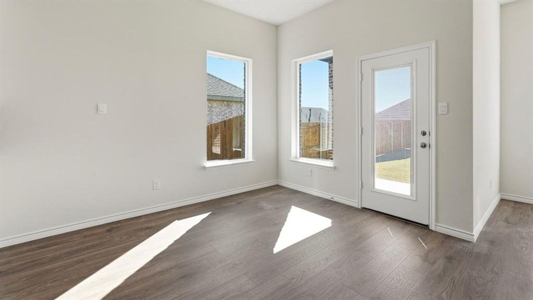 Doorway to outside featuring wood finished floors and baseboards Doorway to outside featuring wood finished floors and baseboards