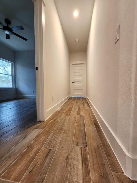 Hallway with hardwood / wood-style flooring and baseboards