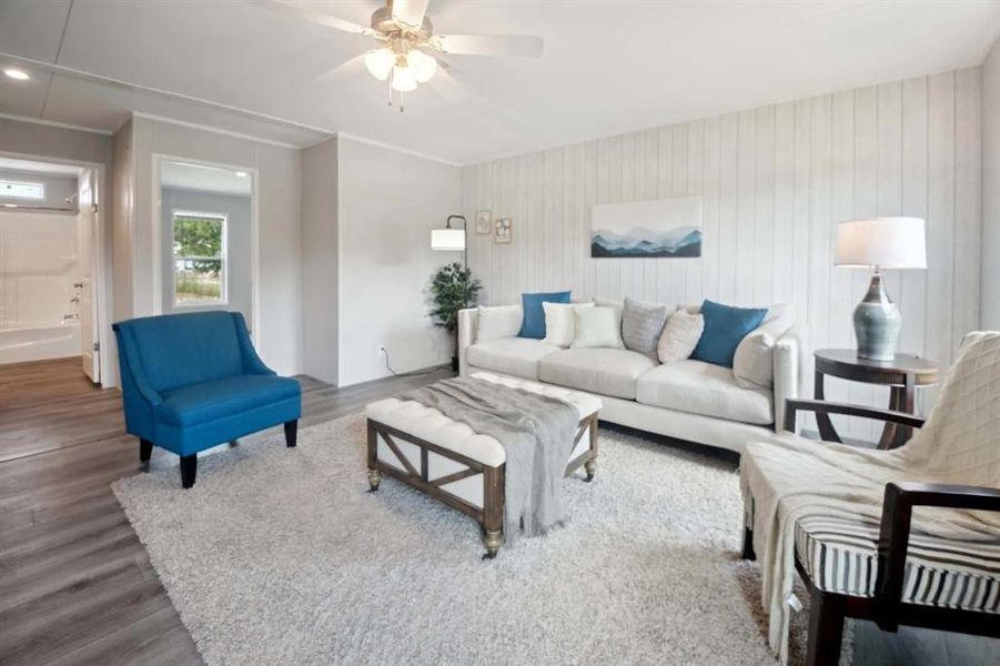 Living room with hardwood / wood-style flooring, ceiling fan, and wooden walls