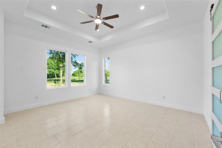 Unfurnished room with a raised ceiling, recessed lighting, light tile patterned floors, and a ceiling fan Unfurnished room with a raised ceiling, recessed lighting, light tile patterned floors, and a ceiling fan