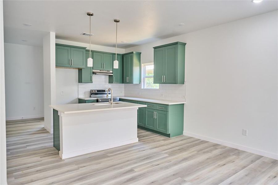 Kitchen featuring a center island with pendant lighting, green cabinetry, white countertops, and a subway tile backsplash