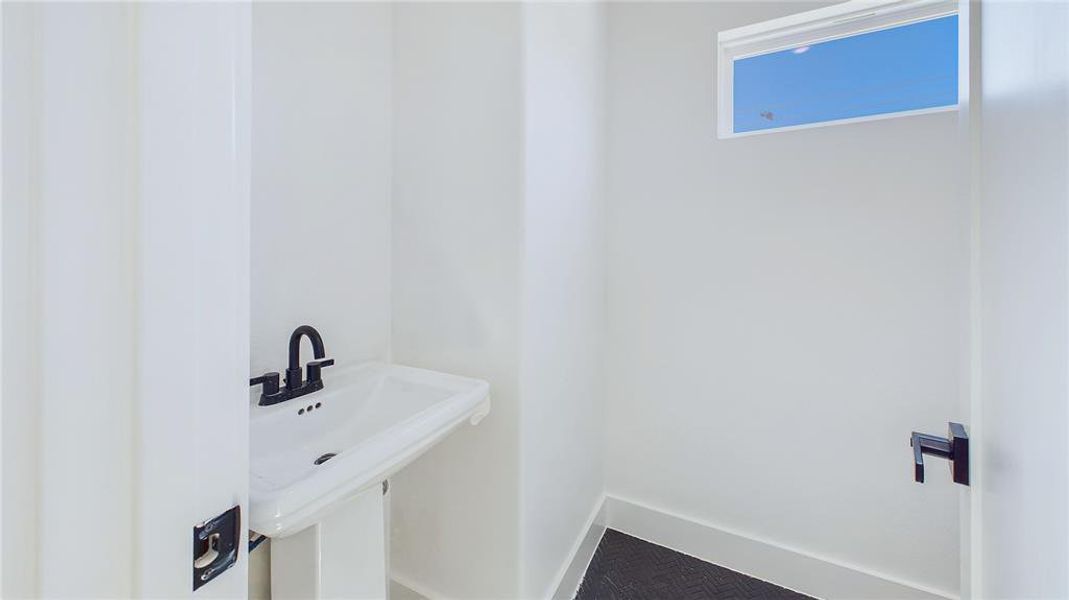 Discreetly tucked to the right of the staircase, out of the main sightline, a conveniently placed half bath is easily accessible to both residents and guests.