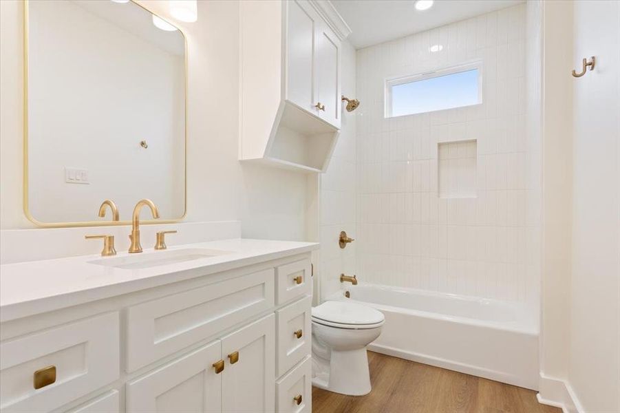 Bathroom featuring vanity, shower / bath combination, and light wood-style flooring