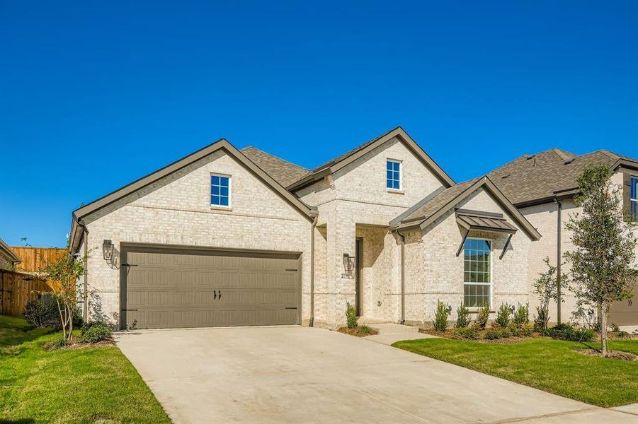 French country home featuring brick siding, concrete driveway, a garage, and roof with shingles