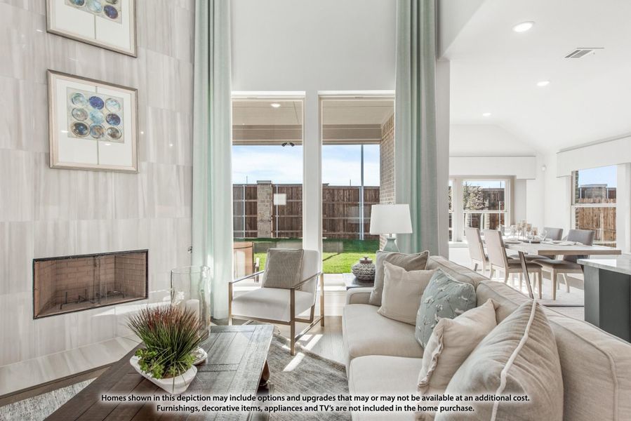 Living room with high ceilings, fireplace, large windows, and open view to backyard patio and dining area Living room with high ceilings, fireplace, large windows, and open view to backyard patio and dining area