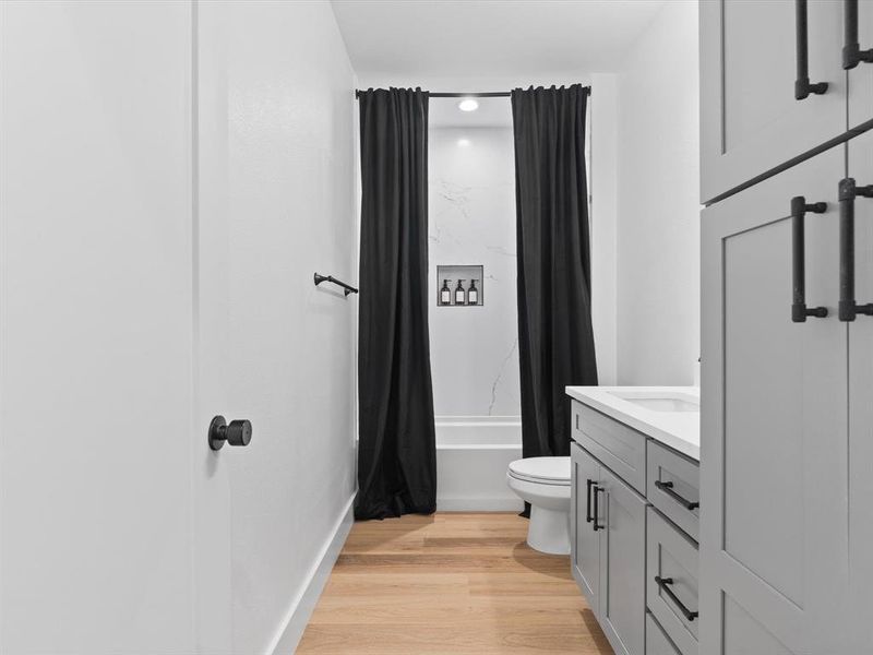 Bathroom with vanity, shower / tub combo with curtain, wood finished floors, toilet, and recessed lighting
