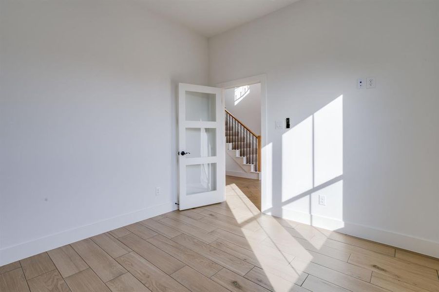 Empty room featuring stairs and light wood-type flooring