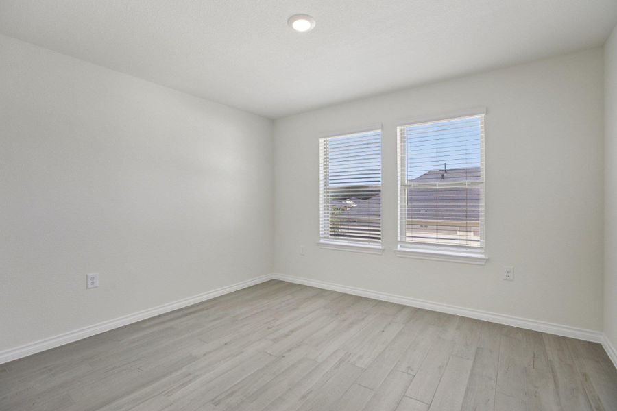 Empty room with baseboards and light wood-style flooring