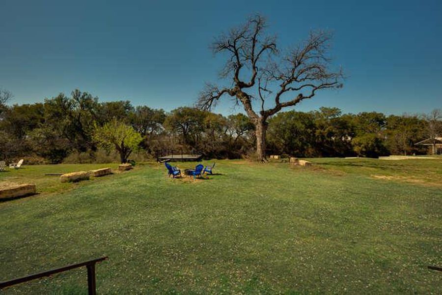 View of grassy yard featuring view of wooded area