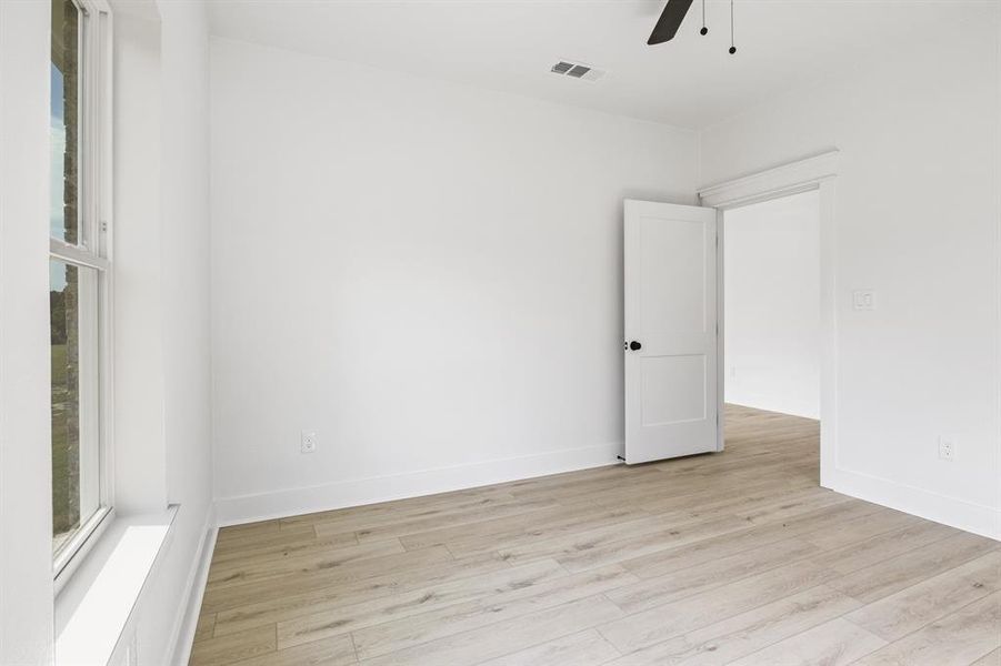 Unfurnished room featuring light wood-type flooring and ceiling fan