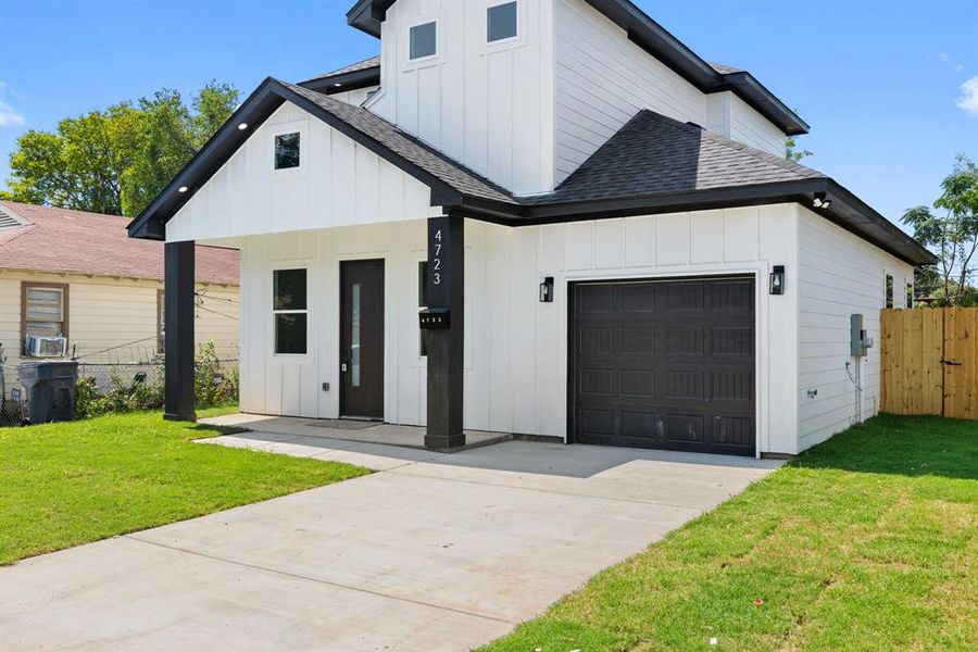 Modern farmhouse featuring board and batten siding, roof with shingles, an attached garage, and driveway