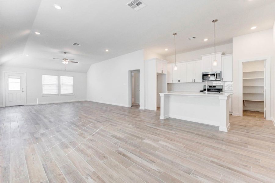 Seamlessly connected, the living room and kitchen create the ultimate open-concept experience. Sleek pendant lighting above the island, modern white cabinetry, and a walk-in pantry elevate the space, while the flowing floorplan offers comfort and functionality. Seamlessly connected, the living room and kitchen create the ultimate open-concept experience. Sleek pendant lighting above the island, modern white cabinetry, and a walk-in pantry elevate the space, while the flowing floorplan offers comfort and functionality.