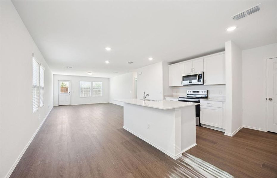 Open kitchen with adjoining nook featuring large windows and direct access to the backyard Open kitchen with adjoining nook featuring large windows and direct access to the backyard