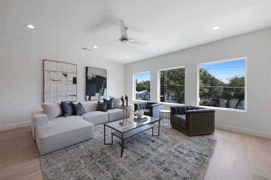 Living room with light wood-style flooring, recessed lighting, and a ceiling fan