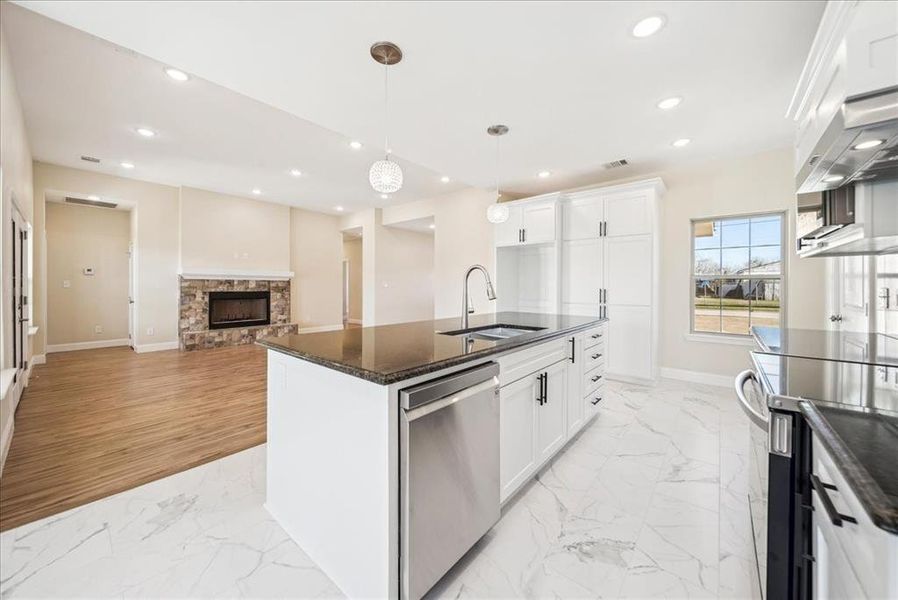 Kitchen featuring white cabinetry, sink, an island with sink, and stainless steel appliances