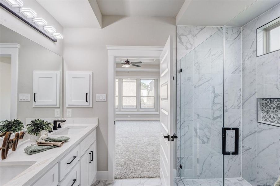 Full bath with double vanity, a custom oversized shower, ceiling fan, and custom tile flooring