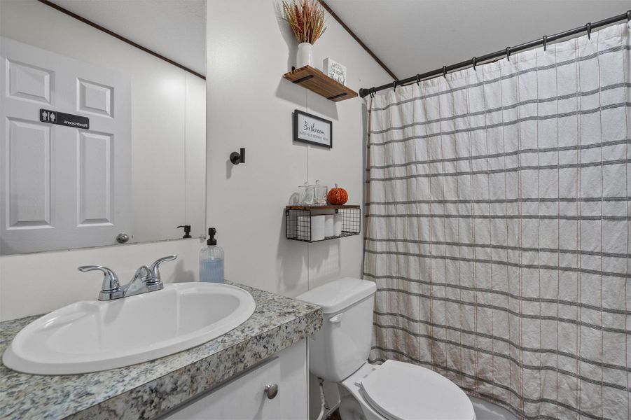 Full bathroom with vanity and a shower with shower curtain